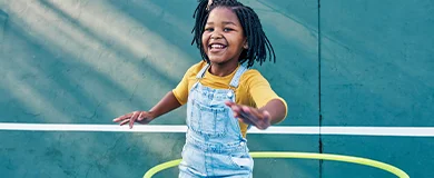 a young girl plays on a tennis court