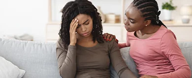 a woman checks on her friend who hit her head