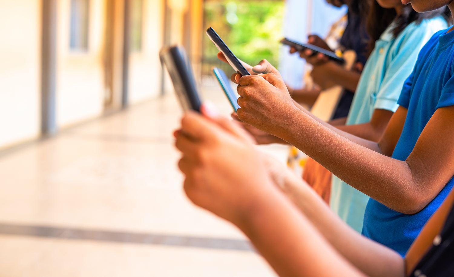 Several children browsing social media on their smart phones.