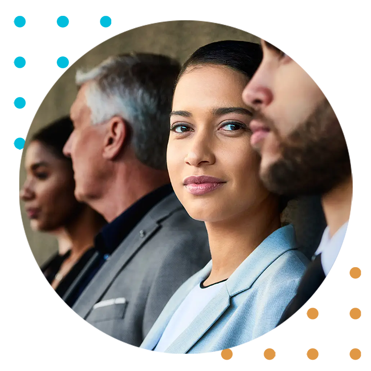 Four government personnel meeting in suits with one person looking over and smiling softly
